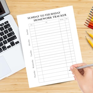 Pode incluir: Um rastreador de tarefas branco intitulado "SUNDAY TO THURSDAY HOMEWORK TRACKER" está em uma superfície de madeira. Um laptop, lápis de cor e lápis também estão presentes. Uma mão segura uma caneta, pronta para escrever no rastreador.