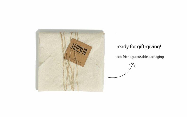 May include: A wrapped package in off-white fabric tied with twine, featuring a brown tag with the text "finegrid". The image includes the text "ready for gift-giving!" and "eco-friendly, reusable packaging".