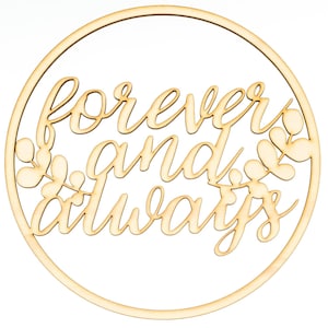 May include: A circular light-colored wooden wall sign featuring the laser-cut text "forever and always" in a cursive script font. The design includes stylized leaf branches extending from the sides of the text within the circular frame.