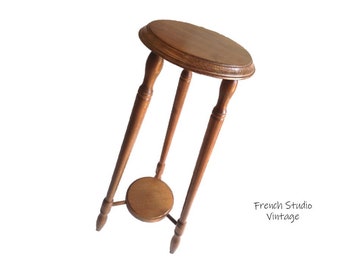 May include: A wooden plant stand with a round top and a lower shelf. The stand is made of dark brown wood and has a simple, elegant design.