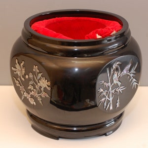 Peut inclure: Un bol en laque noire avec une doublure en velours rouge. Le bol est décoré d'incrustations de nacre de fleurs et d'oiseaux sur des branches.