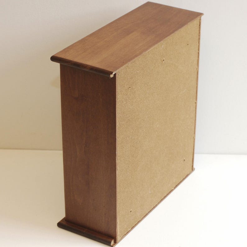 May include: A wooden cabinet with a brown finish and a light brown back panel. The cabinet has a simple design with no visible hardware.