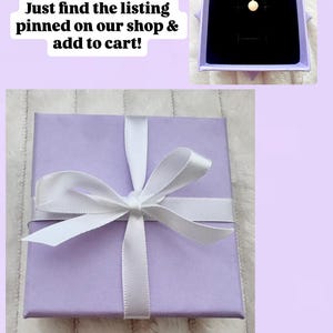 K&ouml;nnte beinhalten: Eine lavendelfarbene Geschenkbox, gebunden mit einem wei&szlig;en Satinband. Der Text auf dem Bild lautet "Optional Add-On: Memento Gift Box" und "Just find the listing pinned on our shop & add to cart!" Eine Halskette wird in einer Box und einem Schmuckbeutel gezeigt.