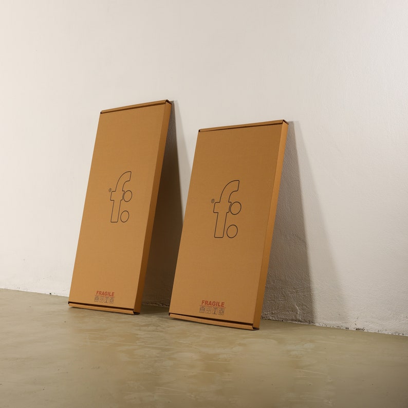 May include: Two brown cardboard boxes with the letter "f" in a circle on the front. The boxes are labeled "Fragile Handle with Care".