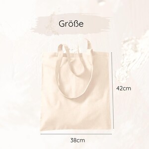 May include: A beige tote bag with a rectangular shape and two handles. The bag measures 38cm wide and 42cm high. The word "Gr&ouml;&szlig;e" is written in black text above the bag.