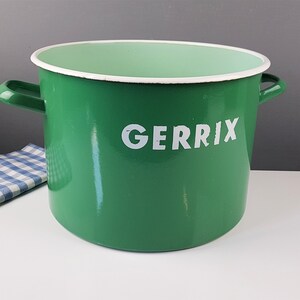 Könnte beinhalten: Grüner Emailletopf mit weißen Griffen und weißem Rand. Der Topf hat den Schriftzug "GERRIX" in weiß auf der Vorderseite.