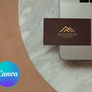 May include: A brown leather business card with a gold mountain logo and the text "Mountain Design Studio".