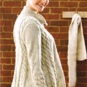 May include: A white cable knit cardigan with a high neck and a long, loose fit. The cardigan has a cable knit pattern on the front and sleeves.