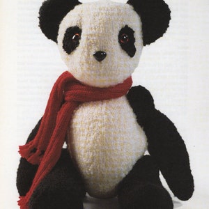 May include: A black and white panda bear plush toy wearing a red scarf. The toy has black ears, a black nose, and black eyes. The toy is sitting on a white background. The text "PANDA" and "Beary special" is printed above the toy.