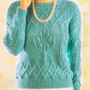 May include: A teal blue knitted sweater with a cable knit pattern and a tree design on the front.