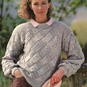 May include: A gray knitted sweater with a geometric pattern and a pink collar.