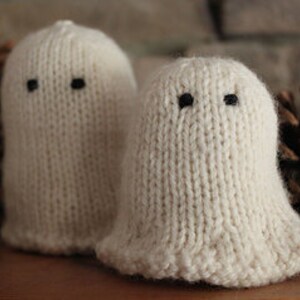 May include: Two small white knitted ghost ornaments with black button eyes.