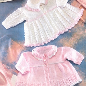 May include: Two knitted baby jackets, one white with pink trim and one pink with white trim. Both jackets have a button closure and a scalloped edge.