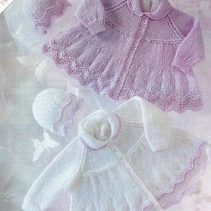 Puede incluir: Dos conjuntos de punto para bebé, uno en blanco con ribete rosa y otro en rosa con ribete blanco. Ambos conjuntos incluyen un gorro a juego.