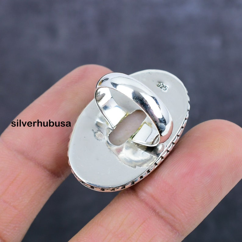May include: Silver ring with an oval shaped setting. The ring is marked with "925" on the inside of the band.