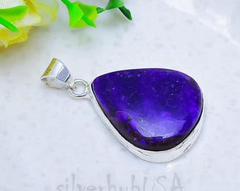 May include: A teardrop-shaped pendant featuring a deep purple stone with a textured, marbled surface, encased in a polished silver-toned metal setting with a simple bail at the top. The text silverhubUSA is visible at the bottom.