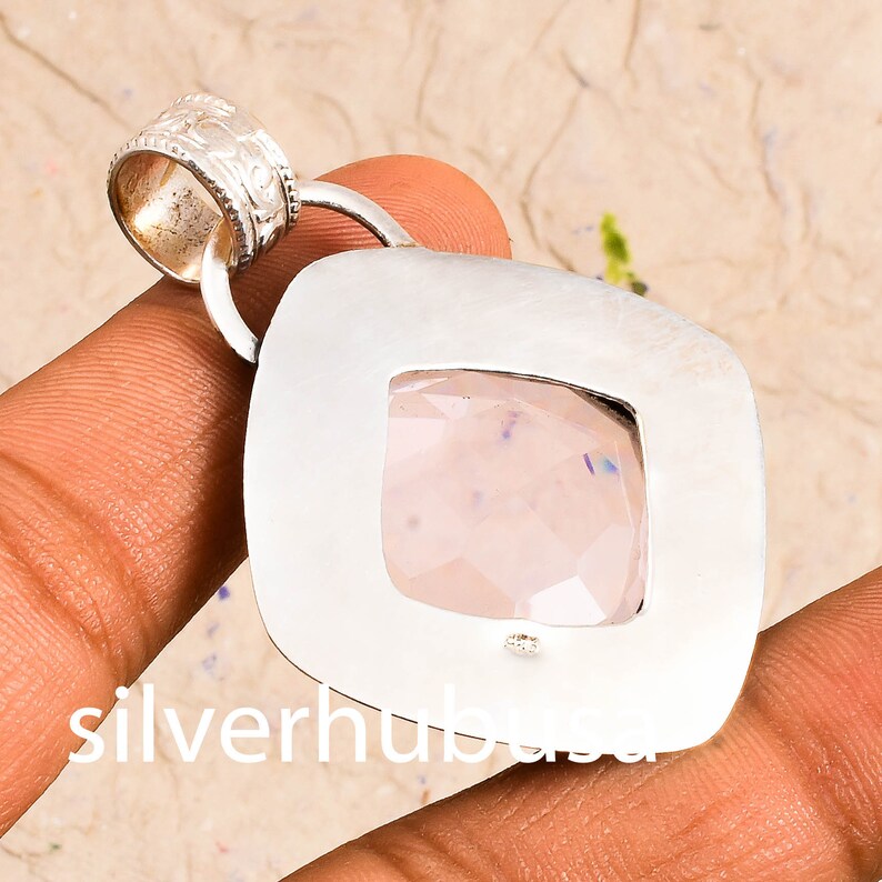 Peut inclure: Un pendentif en argent avec un cadre carr&eacute; et une pierre pr&eacute;cieuse transparente et facet&eacute;e au centre. Le pendentif a une boucle en haut pour attacher une cha&icirc;ne.