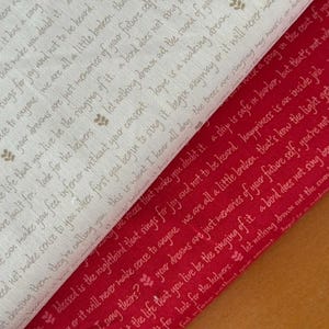 Puede incluir: Dos muestras de tela, una crema y otra roja, con texto impreso en una fuente de escritura. La tela crema tiene texto en color marrón claro, y la tela roja tiene texto en blanco. Las telas están en ángulo diagonal.