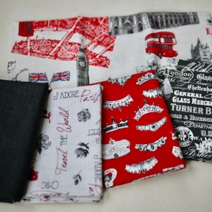 May include: Four fabric swatches with different patterns. The first swatch is white with a red and black map of London, the second is white with a black and red pattern of crowns and the text "J'ADORE Paris" and "Travel the World", the third is red with a black and white pattern of crowns, and the fourth is black with white text that says "London", "Glass", "General Glass Merchants", "Turner Bros", "Oils & Brushes", and "Department".