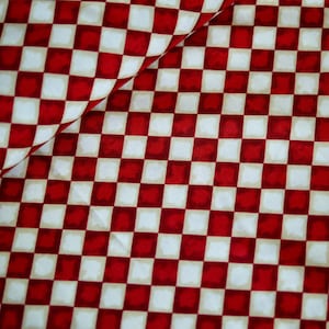 Könnte beinhalten: Nahaufnahme eines rot-weiß karierten Stoffes. Das Muster besteht aus gleichmäßig angeordneten Quadraten in einem klassischen Schachbrettmuster. Der Stoff ist leicht gefaltet, was dem Bild Tiefe verleiht. Die Farbpalette wird von Rot und Weiß dominiert.