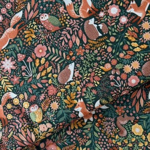 Könnte beinhalten: Ein dunkelgrüner Stoff mit einem sich wiederholenden Muster von Waldtieren und Pflanzen. Das Design umfasst Füchse, Eulen, Igel, Blumen, Pilze und Blätter in Orange-, Rosa-, Gelb- und Brauntönen.