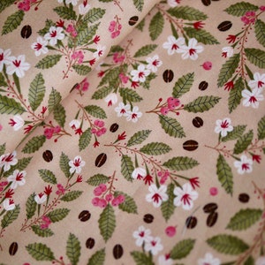 May include: Beige fabric with a repeating pattern of white flowers, green leaves, and brown coffee beans.