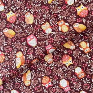 Peut inclure: Tissu à motifs répétés d'hiboux colorés, de feuilles et de baies. Les hiboux sont dans des tons d'orange, de jaune, de rose et de blanc, sur un fond bordeaux foncé. Idéal pour les projets de couture.