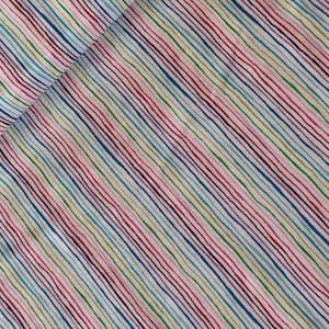 Könnte beinhalten: Stoff mit einem sich wiederholenden Muster aus diagonalen, mehrfarbigen Streifen. Die Streifen sind in Rot-, Blau-, Grün- und Gelbtönen auf weißem Hintergrund gehalten. Der Stoff ist in der oberen linken Ecke gefaltet.