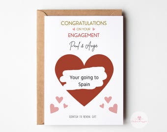 May include: A white card with a red heart and the text "Congratulations on your engagement Paul & Ange Your going to Spain Scratch to reveal gift".