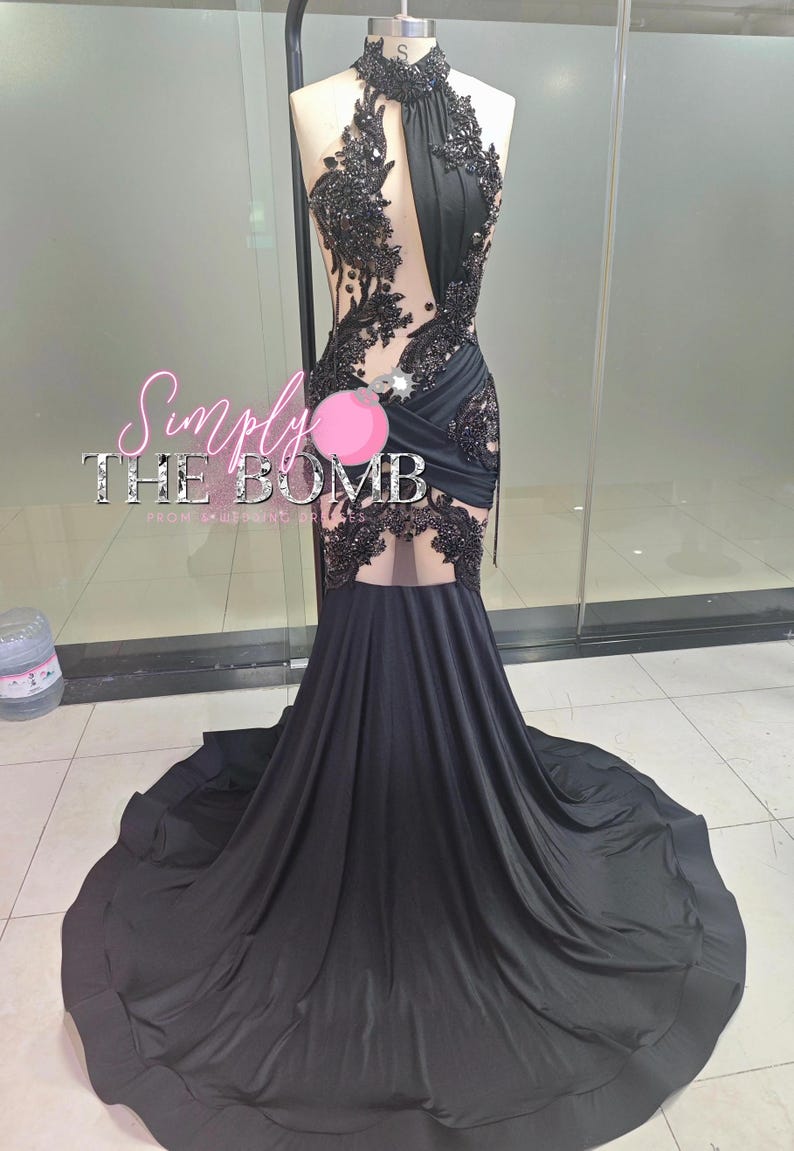 May include: A black formal gown with a halter neckline and a flowing train. The bodice features intricate black lace and beadwork. The text "Simply THE BOMB" is visible on the image.