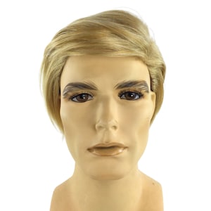 Op de afbeelding: Een mannequinhoofd met een lichte huidskleur, bruine ogen en kort, gestyled blond haar. De mannequin heeft geschilderde wenkbrauwen en wimpers en een neutrale uitdrukking. Het hoofd staat tegen een effen witte achtergrond.