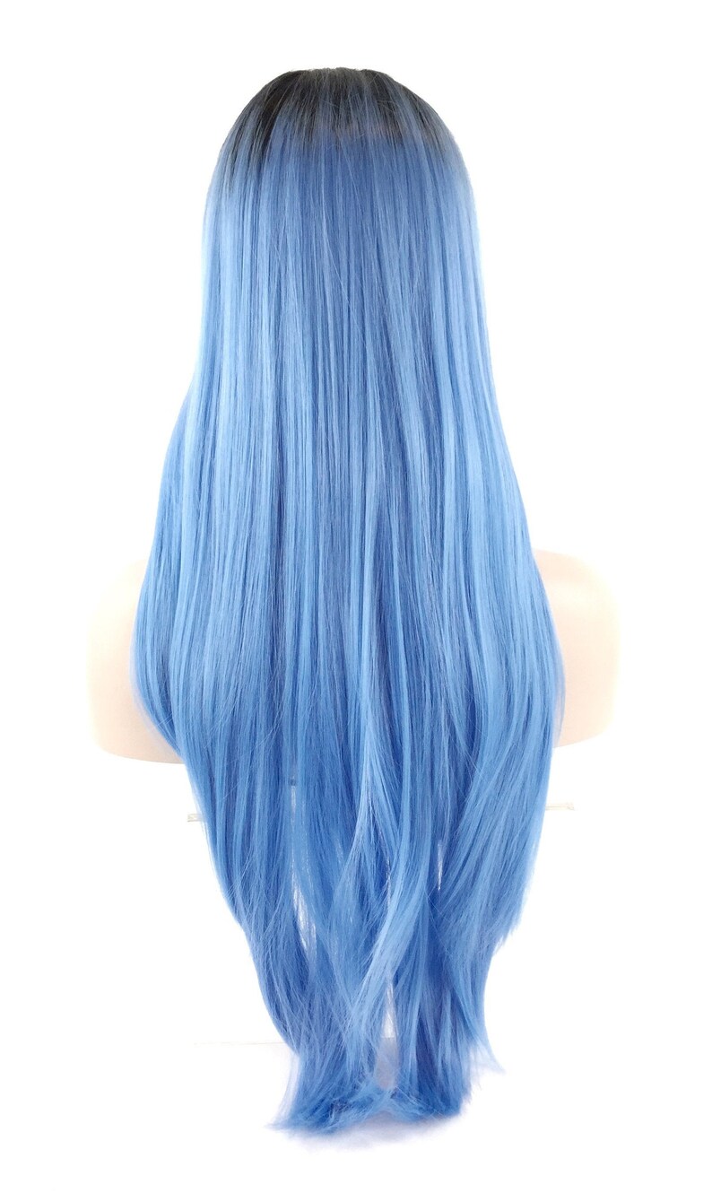 May include: A long, light blue wig with a dark root. The wig is styled with long, straight strands that cascade down the back. The wig is displayed on a mannequin head against a white background.