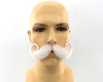 May include: A mannequin head with a white, curled mustache. The mannequin has brown eyebrows and eyes, and a light skin tone. The mustache is thick and fluffy, with the ends curled upwards.