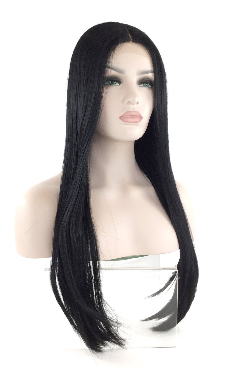 Puede incluir: Peluca negra de pelo liso sobre una cabeza de maniqu&iacute;. La peluca presenta una l&iacute;nea de cabello natural y mechones largos y lisos. El maniqu&iacute; tiene tez clara, ojos verdes y una expresi&oacute;n neutra. El fondo es blanco.
