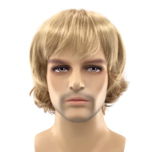 May include: A mannequin head featuring a short, layered blonde wig with a side-swept fringe. The mannequin has a neutral facial expression, defined eyebrows, light-colored eyes, and a subtle hint of facial hair around the jaw and mouth area.