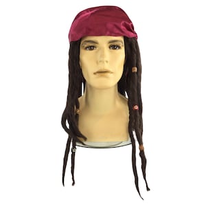 May include: A costume wig featuring long, dark brown dreadlocks with decorative beads. The wig is topped with a maroon bandana. The wig is displayed on a mannequin head against a white background.