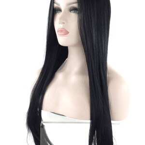 Puede incluir: Una peluca negra con cabello largo y liso se muestra en una cabeza de maniqu&iacute;. La peluca presenta una l&iacute;nea de cabello de aspecto natural y una textura elegante y brillante. El maniqu&iacute; tiene una tez clara y est&aacute; sobre un fondo blanco.