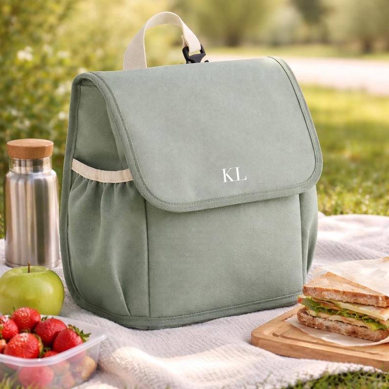 Green personalised cooler bag for kids with snacks and bottle
Kids picnic lunch bag with sandwiches fruit and drinks
Custom name lunch bag for school and nursery