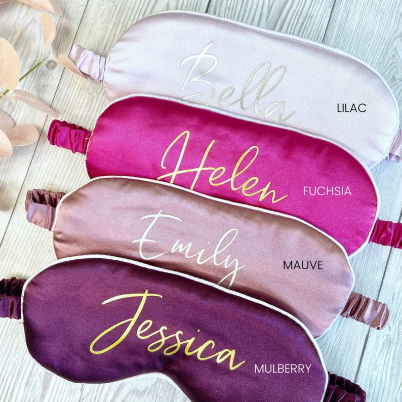 May include: Four satin sleep masks in different colors with names embroidered on them. The colors are lilac, fuchsia, mauve, and mulberry.