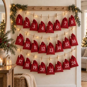 May include: A wall-mounted advent calendar featuring twenty-four small red fabric drawstring bags hanging from three horizontal jute strings. Each bag is numbered in white from 1 to 24 and secured with a wooden clothespin, illuminated by string lights.