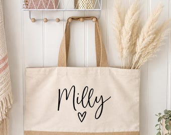May include: A rectangular canvas tote bag with a natural tan jute base and matching fabric handles. The front of the bag features the name Milly printed in black cursive script, accompanied by a small black heart icon centered below the name.