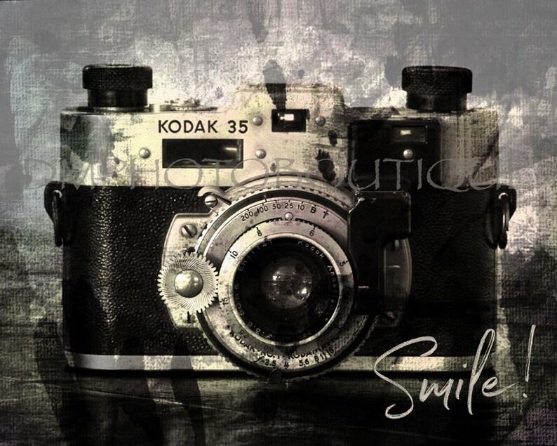 May include: A vintage black and silver Kodak 35 camera with a lens and a silver dial that reads "200 400 30 25 10 8 T B". The camera is on a textured background with the word "Smile!" written in white.