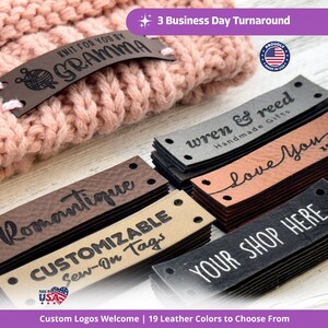 May include: Rectangular leather sew-on tags in various colors including dark brown, tan, and black, featuring engraved text such as "KNIT FOR YOU BY GRAMMA," "wren & reed," "love You," "Romantique," "CUSTOMIZABLE Sew-On Tags," and "YOUR SHOP HERE."