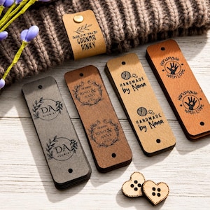 May include: Rectangular leather tags in gray, light brown, and dark brown with black printed text and graphics including 'DA Florist', 'Rino & Sany', 'Handmade by Nana', and 'Handmade with Love'. Two heart-shaped wooden buttons are included.