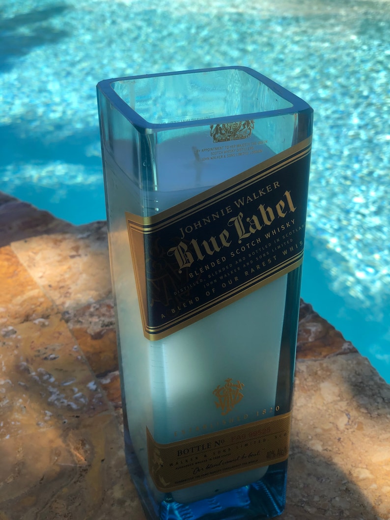 May include: A clear glass candle holder with a blue label that reads "JOHNNIE WALKER Blue Label Blended Scotch Whisky" and "A blend of our rarest whiskies".