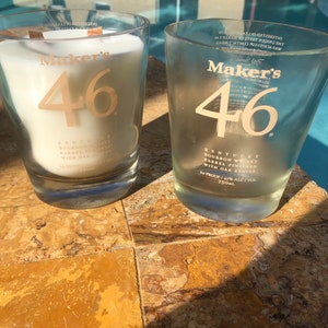 May include: Two clear glass bottles with Maker's 46 Kentucky Bourbon Whiskey labels. The bottles are sitting on a brown tiled surface.