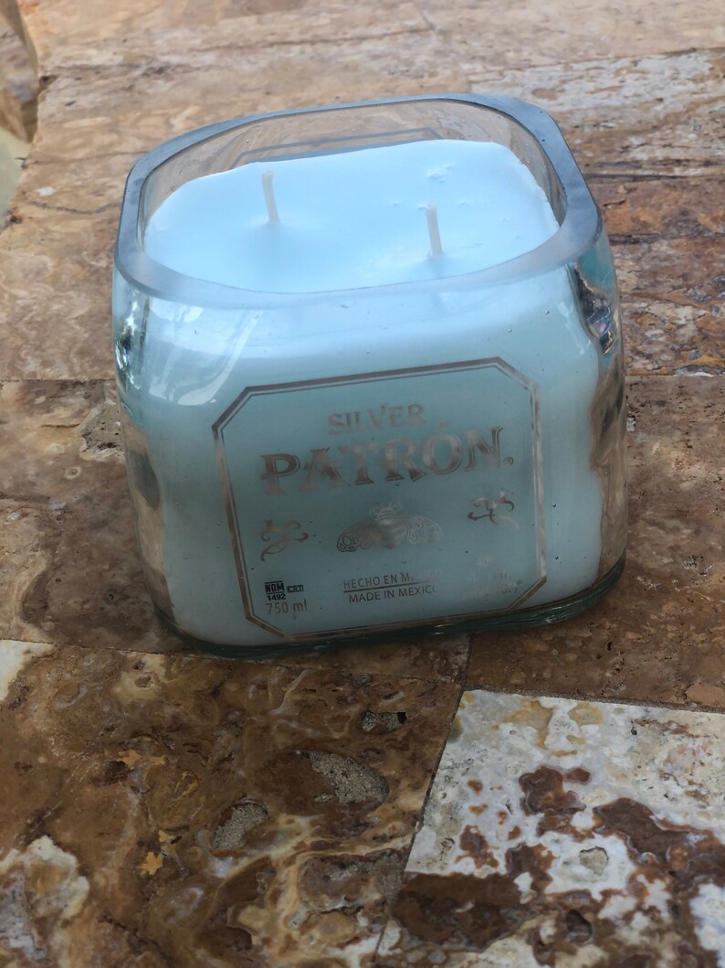 May include: A blue candle in a clear glass bottle with the label "SILVER PATRON" and "HECHO EN M. MADE IN MEXICO".