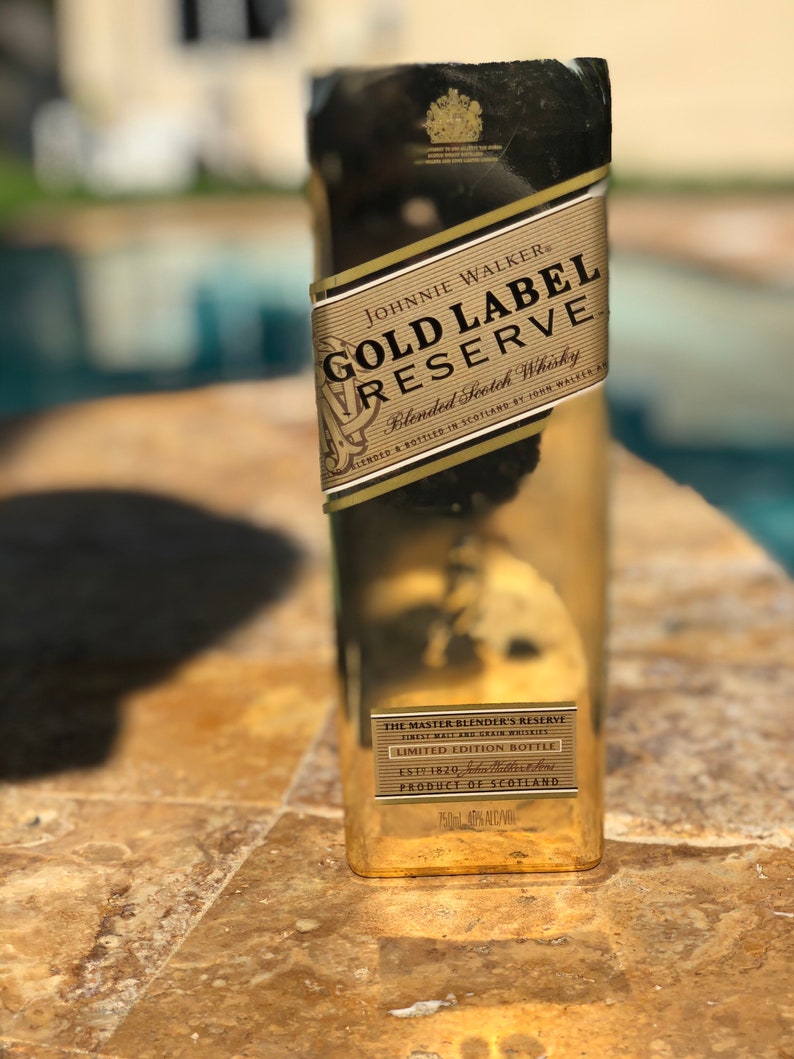 May include: A gold bottle of Johnnie Walker Gold Label Reserve Blended Scotch Whisky. The bottle has a label with the text "The Master Blender's Reserve" and "Limited Edition Bottle".