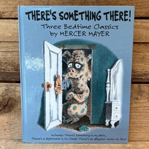 May include: A blue book cover with the title "There's Something There!" and the subtitle "Three Bedtime Classics by Mercer Mayer". The cover features an illustration of a monster peeking out from behind a door.