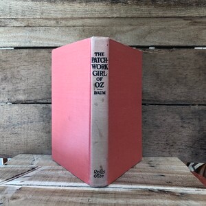 May include: A red hardcover book titled "The Patchwork Girl of Oz" by Baum. The book is published by Reilly & Lee.